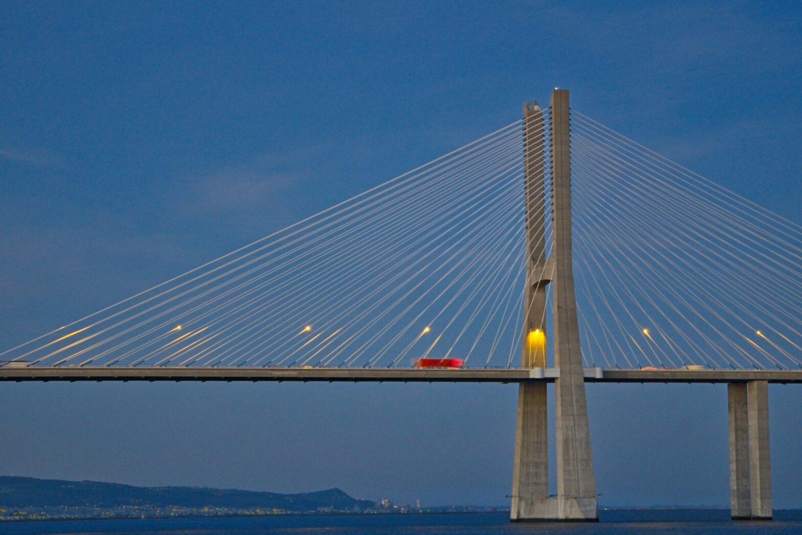 a red car is driving across a bridge