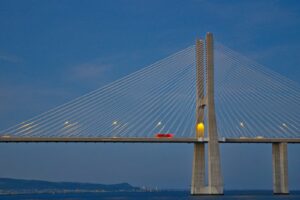 a red car is driving across a bridge