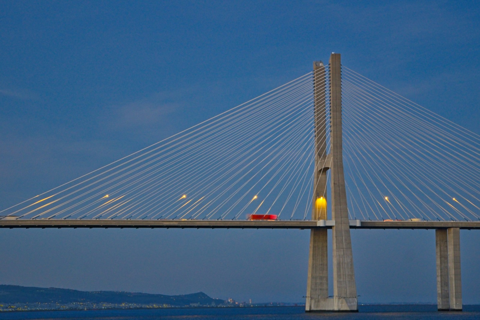 a red car is driving across a bridge